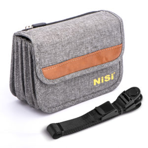 NiSi Caddy 100mm Filter Pouch in grey fabric with a tan leather stripe and yellow NiSi logo, flap closed, with its black sling strap coiled beside it