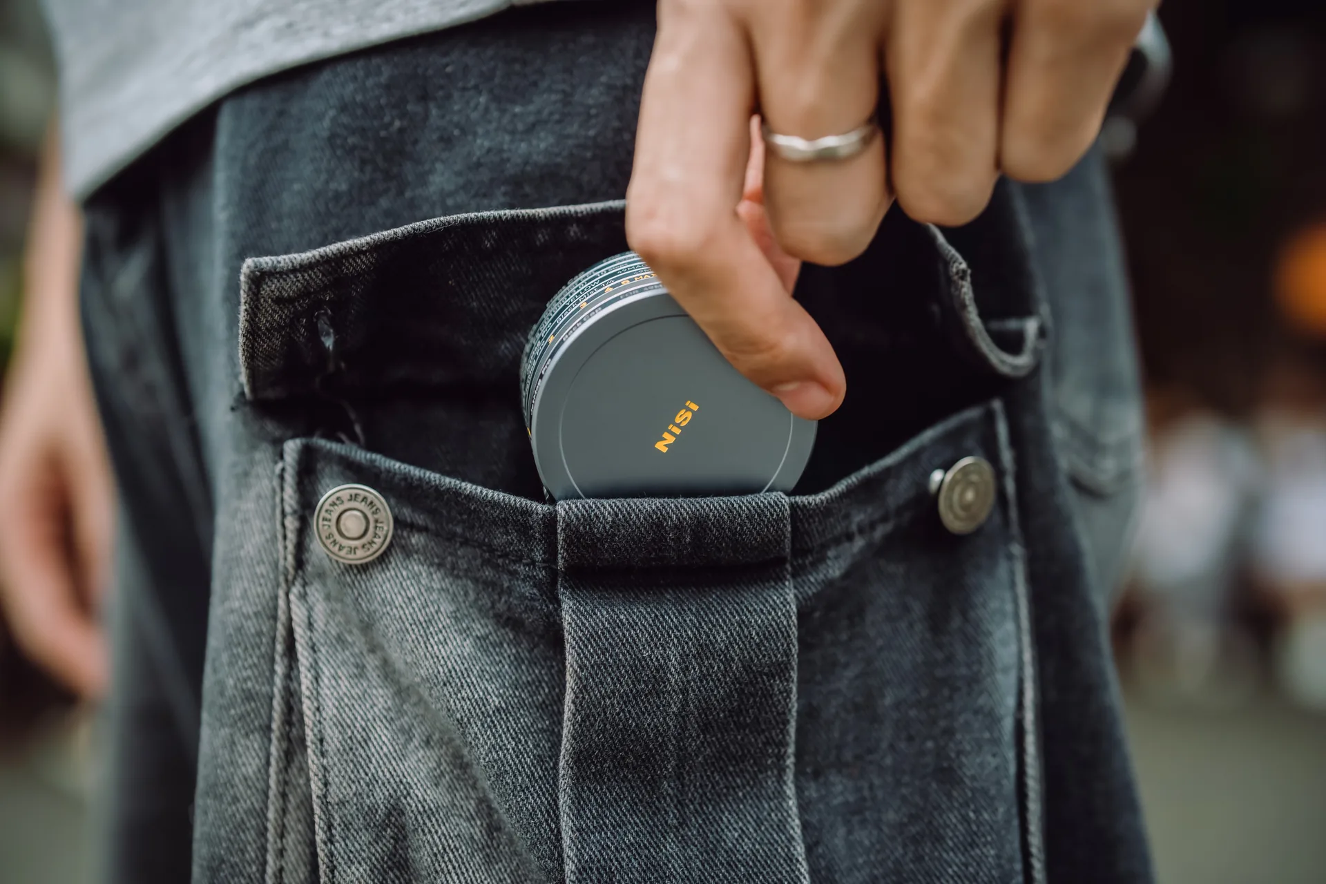 A stack of 49MAG filters slipping into a jeans pocket