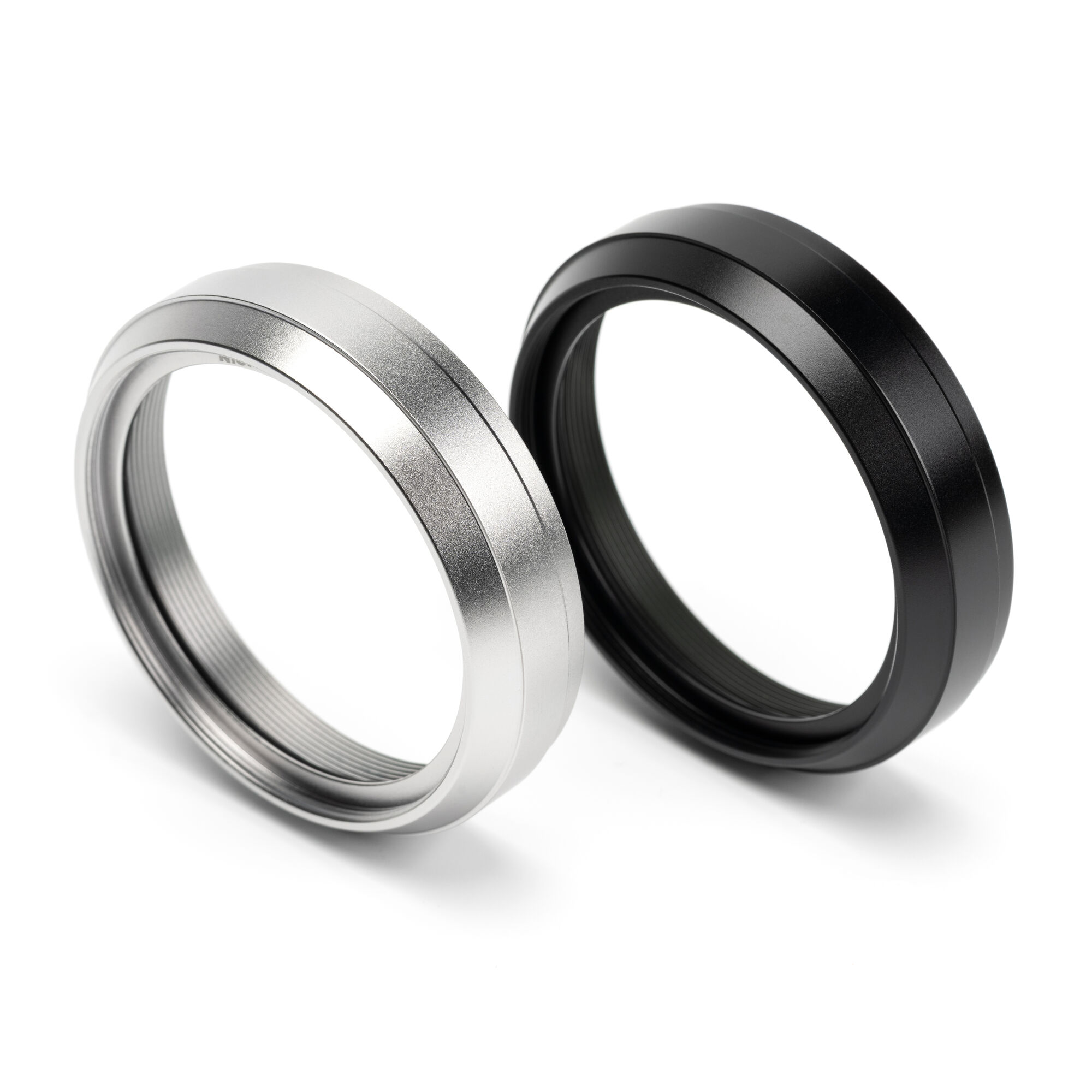 The NiSi NC UV Filter II with 49mm front thread in silver and in black, standing side by side on white