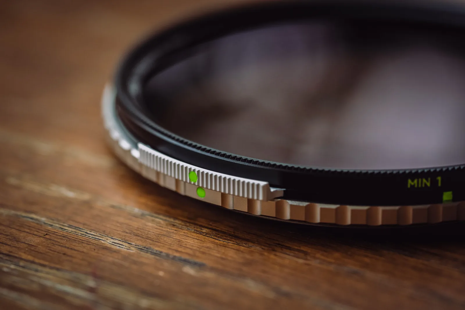 The slim knurled silver frame of a NiSi True Color VND/PL resting on wood