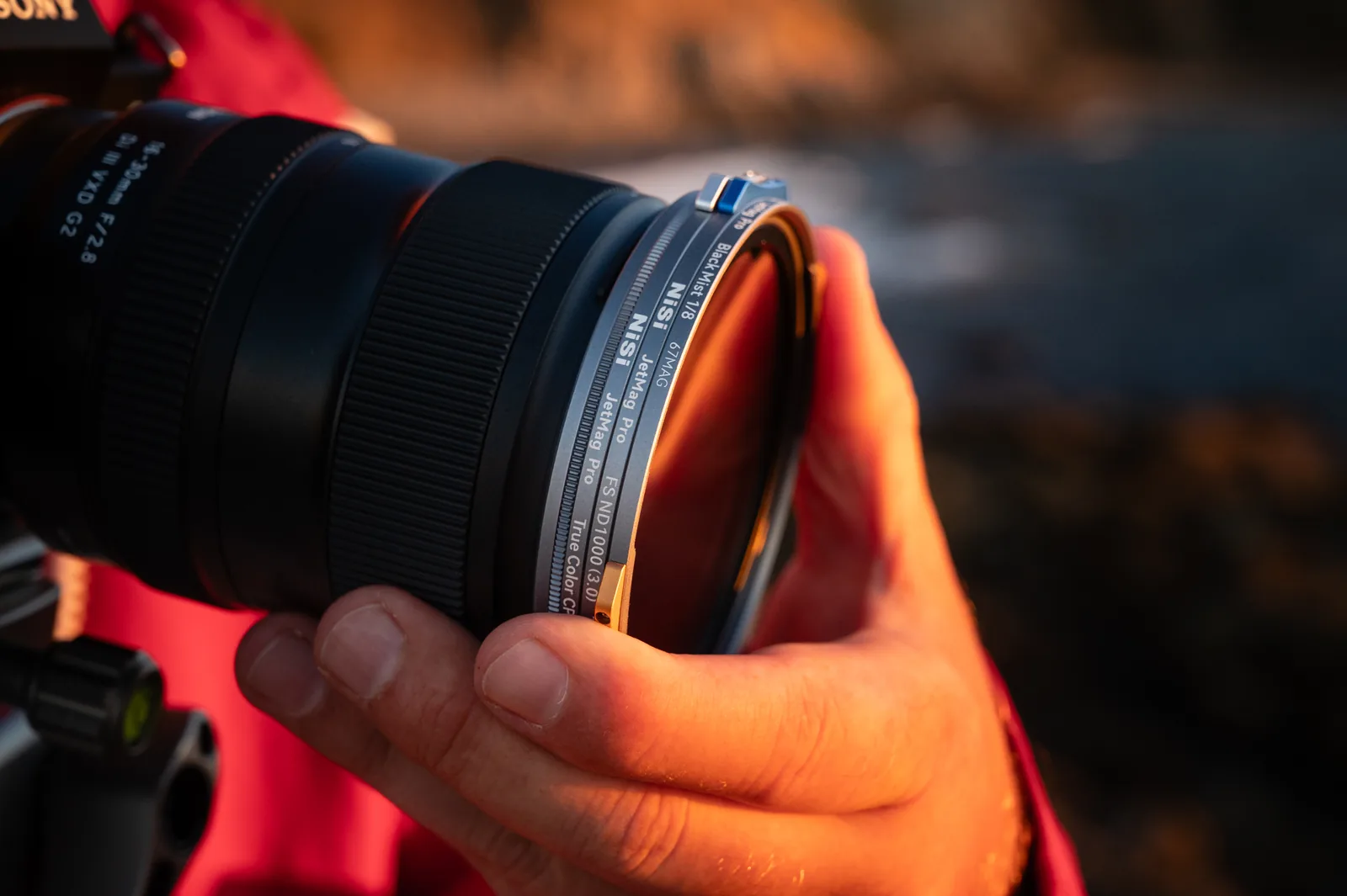 Twisting a 67MAG filter to lock it on a lens at sunset