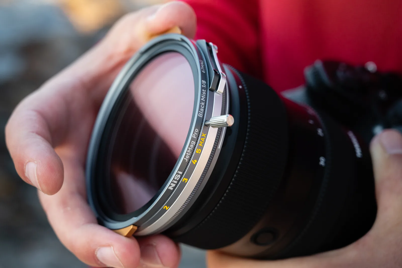 Placing a 67MAG filter onto a lens by the sea