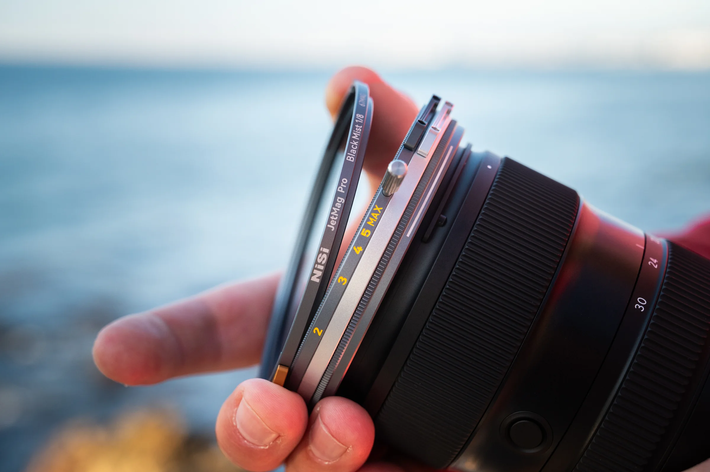 Stacking NiSi JetMag Pro 67MAG filters onto a lens by the ocean