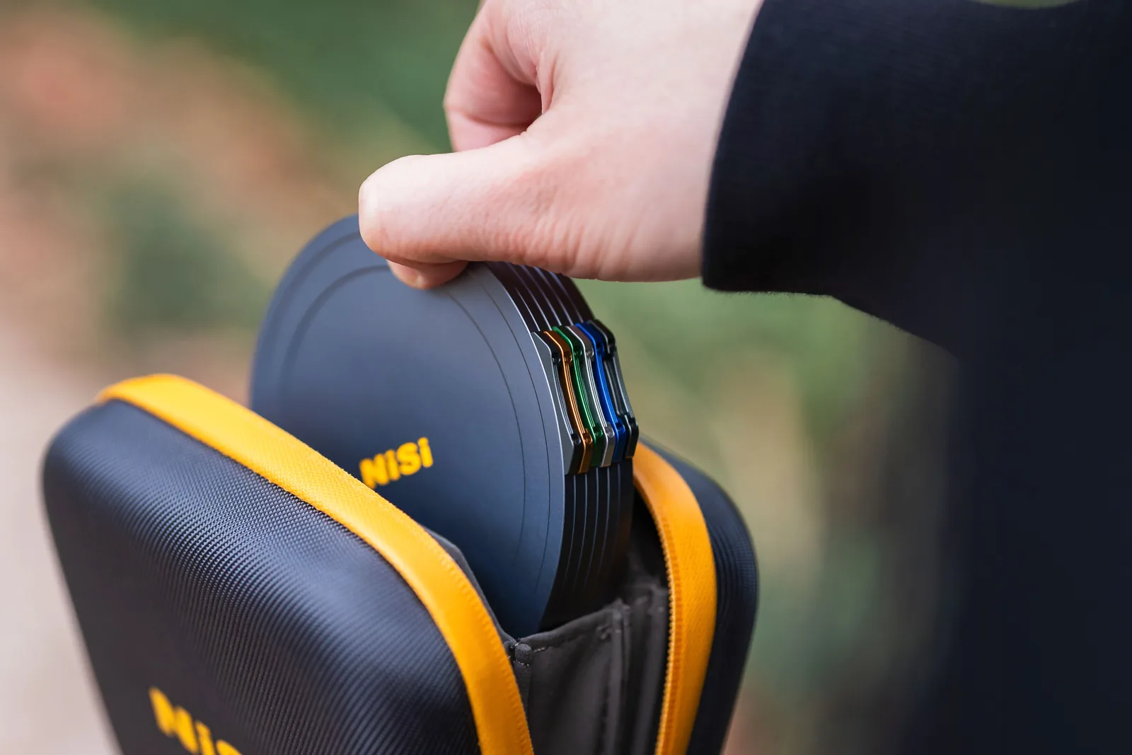 A capped stack of NiSi JetMag Pro filters being lifted out of a NiSi Caddy Pouch