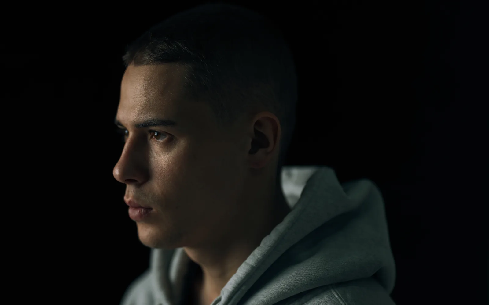 A portrait of a man lit low against a dark background