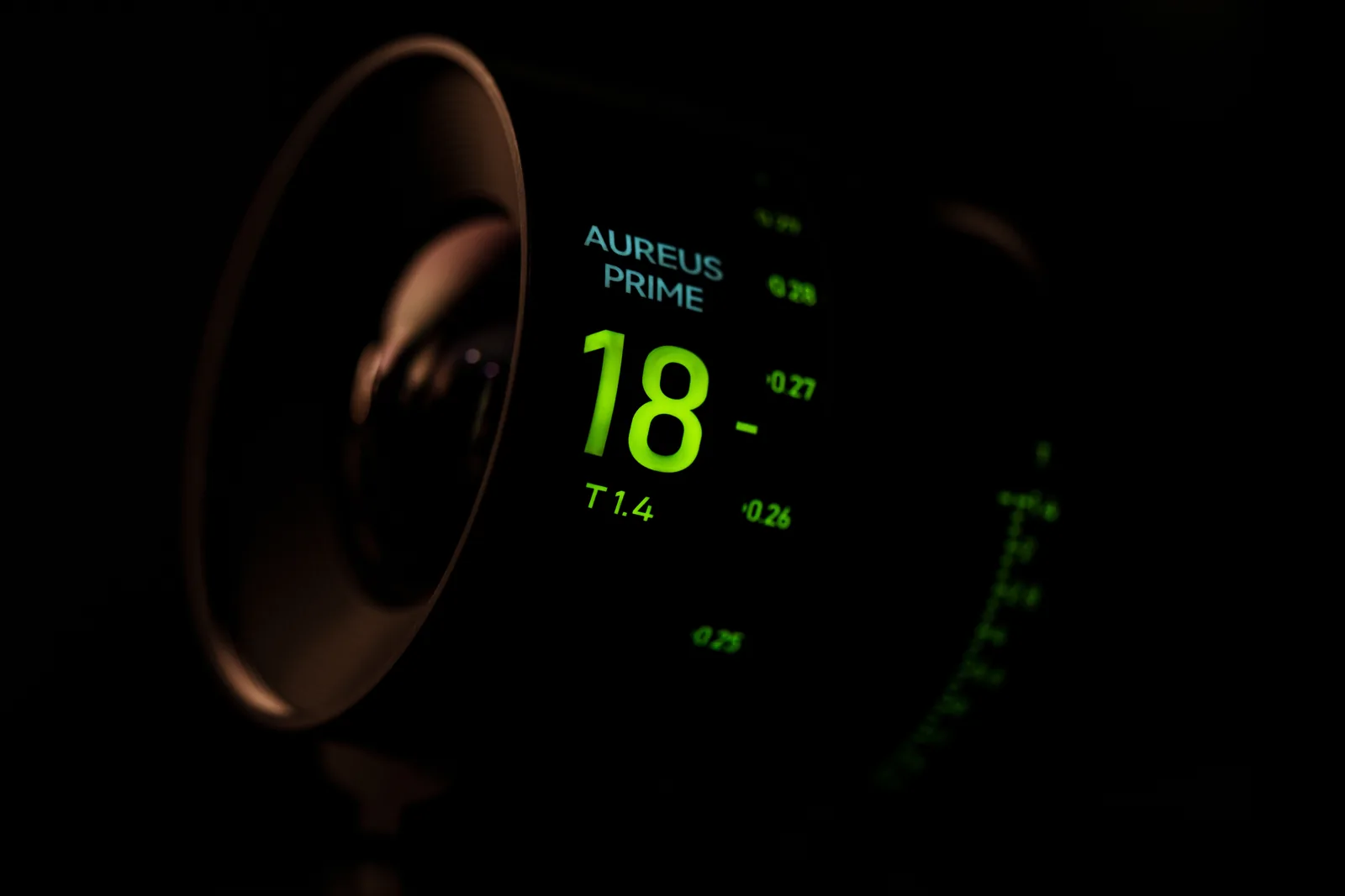 Glowing focal length and T-stop markings on an AUREUS PRIME 18mm lens in the dark