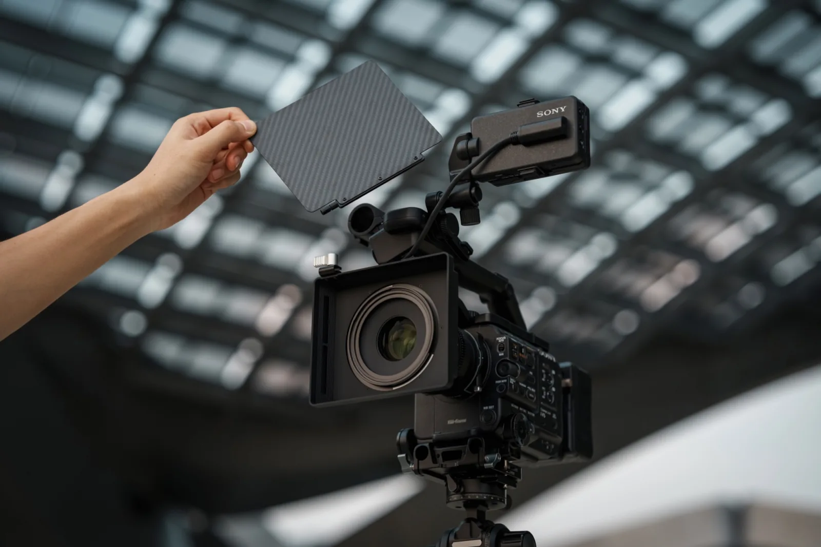 A hand lifting the carbon fiber top flag off the NiSi JetMag Pro Matte Box